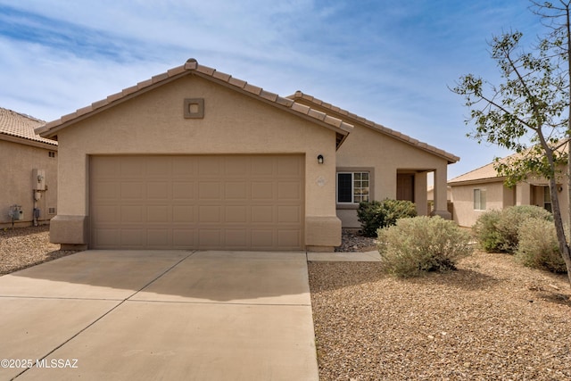 view of front of house featuring stucco siding, a garage, driveway, and a tiled roof