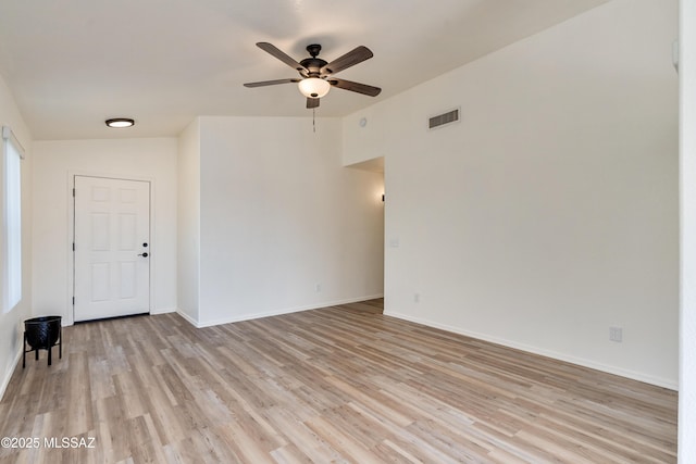 empty room with baseboards, light wood-style floors, visible vents, and ceiling fan