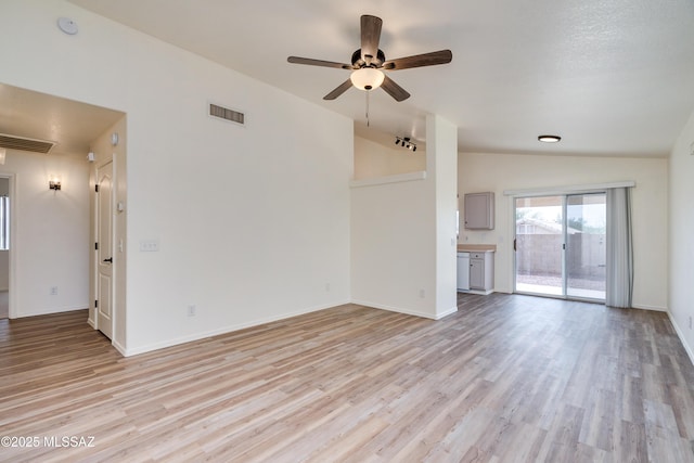 unfurnished living room with visible vents, lofted ceiling, light wood-style floors, and baseboards