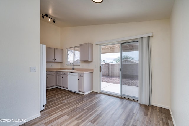 kitchen with white appliances, light wood-style floors, gray cabinets, and lofted ceiling