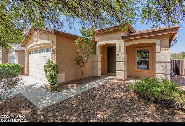 view of front of house featuring concrete driveway, an attached garage, and stucco siding