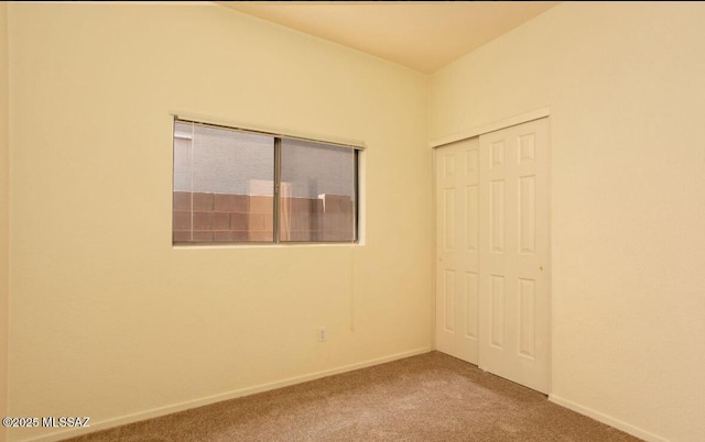 empty room featuring carpet floors and baseboards