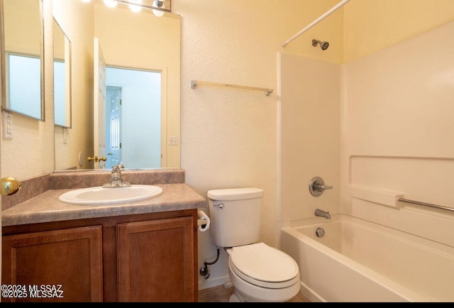 bathroom featuring toilet, shower / bathtub combination, a textured wall, and vanity