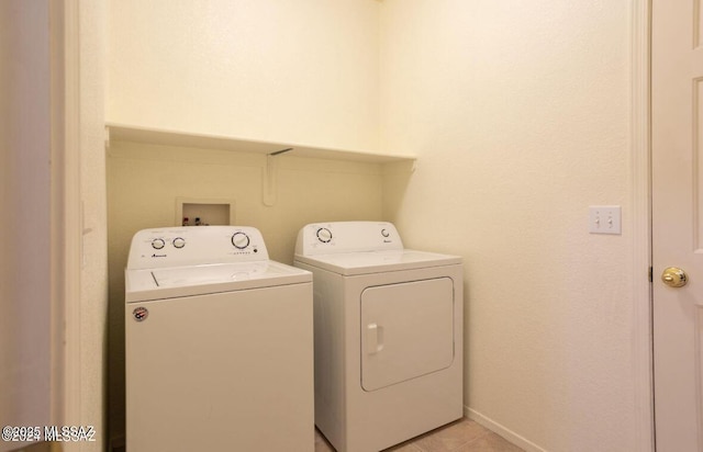 washroom featuring laundry area, baseboards, and separate washer and dryer