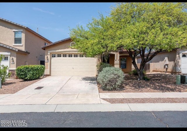 view of front of home featuring a garage, driveway, and stucco siding