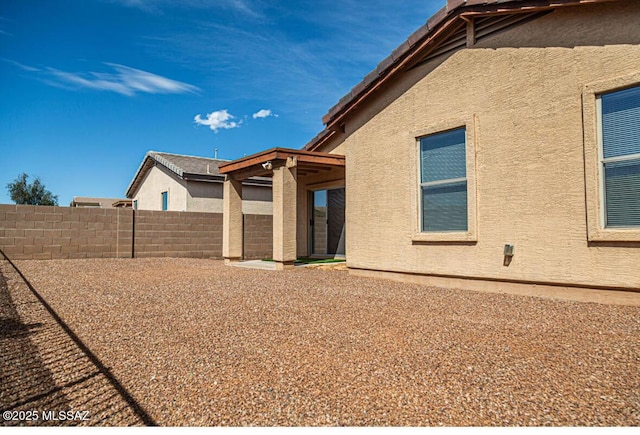 view of property exterior with fence and stucco siding