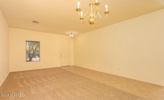 empty room with a chandelier, visible vents, and light colored carpet