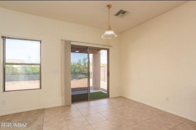 spare room featuring light tile patterned floors, baseboards, and visible vents