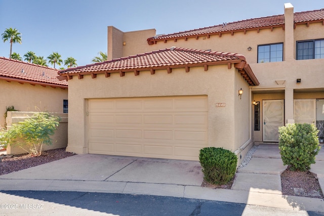 mediterranean / spanish home with driveway, an attached garage, and stucco siding