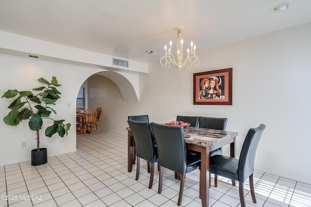 dining area featuring arched walkways, light tile patterned floors, visible vents, and a notable chandelier