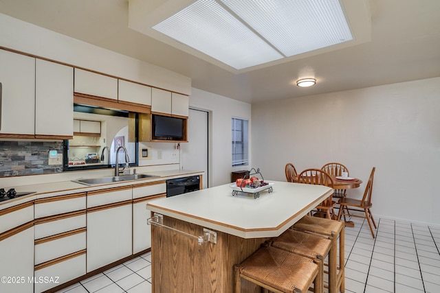 kitchen featuring light tile patterned floors, white cabinetry, and a sink