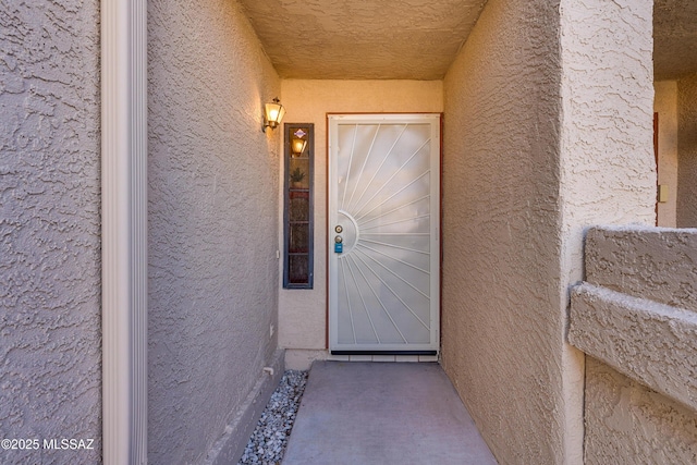 view of exterior entry featuring stucco siding