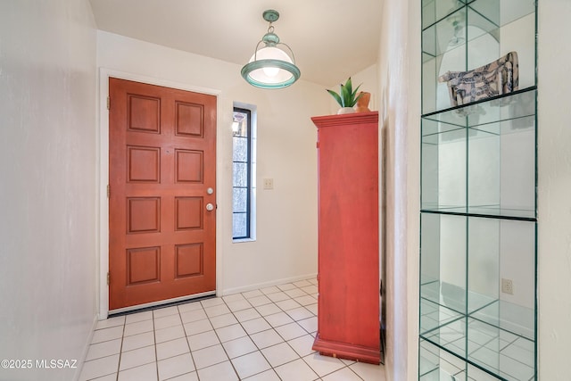 foyer entrance with light tile patterned floors and baseboards