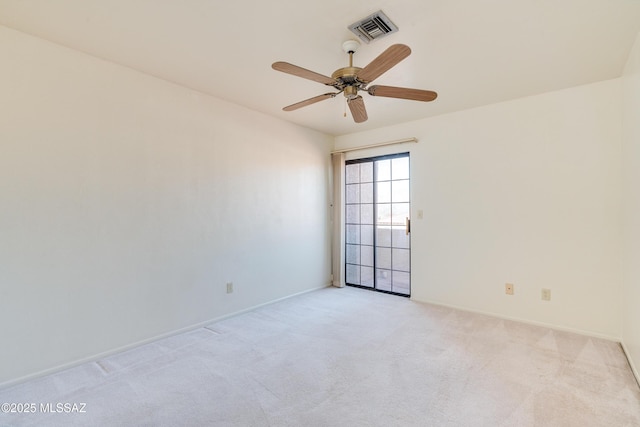 carpeted empty room with a ceiling fan, visible vents, and baseboards