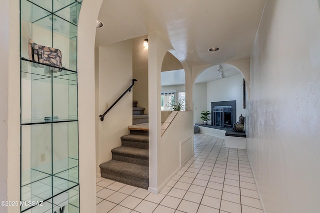 stairway featuring tile patterned flooring and a tiled fireplace