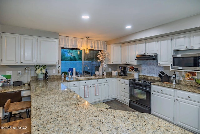 kitchen featuring white cabinets, stainless steel microwave, black range with electric stovetop, under cabinet range hood, and a sink