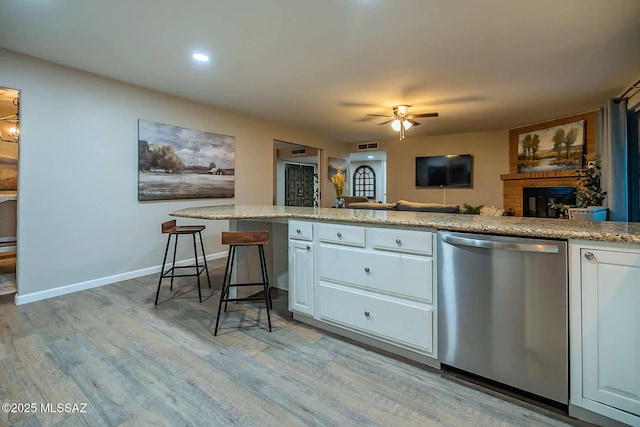 kitchen with baseboards, white cabinets, dishwasher, light wood-style flooring, and ceiling fan