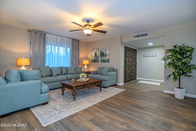 living area with visible vents, ceiling fan, baseboards, and wood finished floors