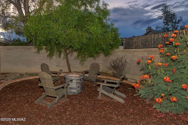 view of yard featuring an outdoor fire pit and a fenced backyard