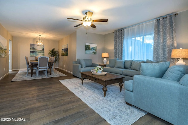 living room featuring a ceiling fan, dark wood-style flooring, and baseboards