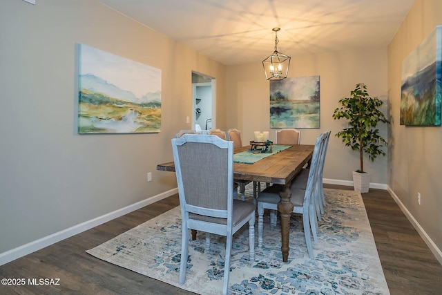 dining space featuring a notable chandelier, baseboards, and wood finished floors