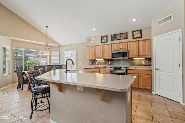 kitchen featuring a breakfast bar area, light countertops, visible vents, appliances with stainless steel finishes, and a sink