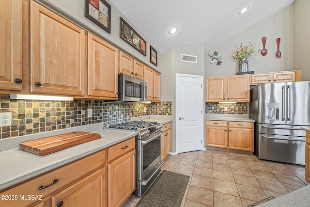 kitchen with vaulted ceiling, visible vents, stainless steel appliances, and light countertops