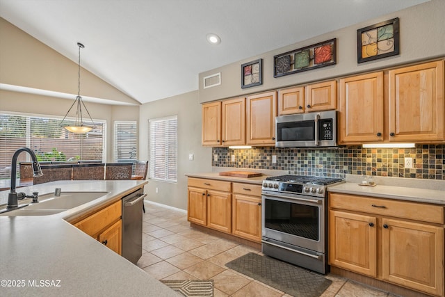 kitchen with visible vents, decorative backsplash, lofted ceiling, appliances with stainless steel finishes, and a sink