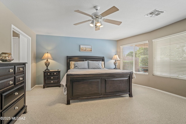 bedroom featuring baseboards, visible vents, ceiling fan, and light colored carpet