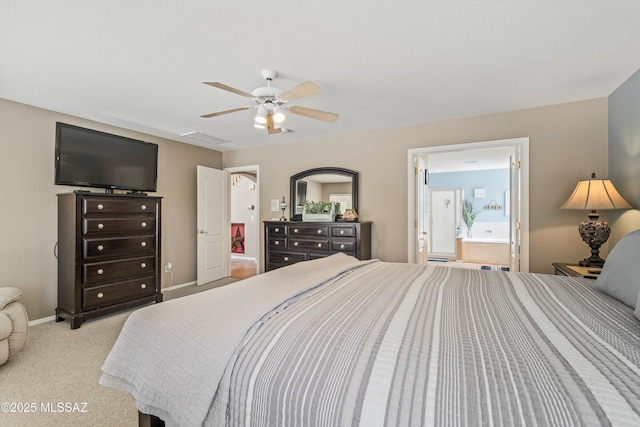 bedroom featuring baseboards, ensuite bathroom, a ceiling fan, and light colored carpet