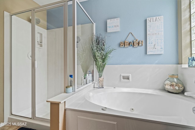 bathroom with a jetted tub and a stall shower