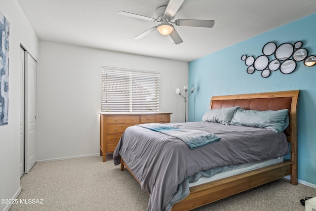 bedroom with ceiling fan, baseboards, a closet, and light colored carpet