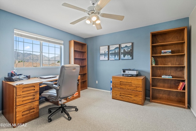 office with a mountain view, carpet flooring, a ceiling fan, and baseboards