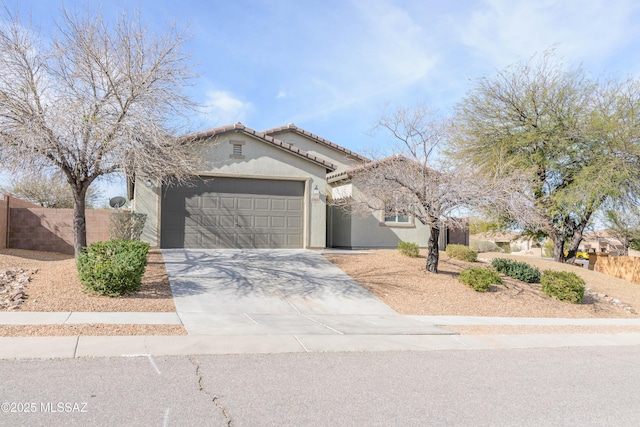 view of front of home with an attached garage, fence, a tile roof, driveway, and stucco siding