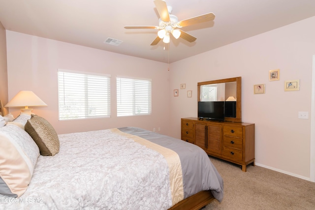 carpeted bedroom with a ceiling fan, visible vents, and baseboards