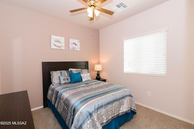 carpeted bedroom with a ceiling fan, visible vents, and baseboards