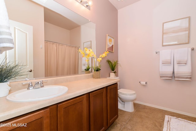 bathroom with tile patterned flooring, baseboards, vanity, and toilet