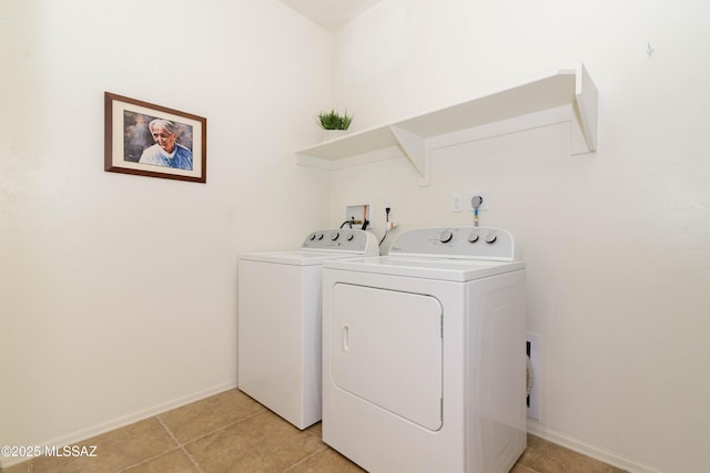 laundry room with laundry area, washing machine and dryer, light tile patterned floors, and baseboards