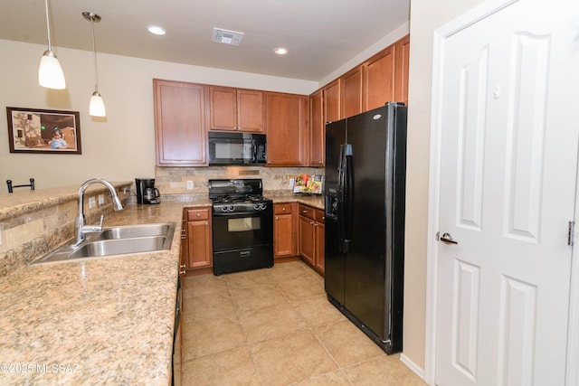 kitchen with tasteful backsplash, light countertops, visible vents, a sink, and black appliances