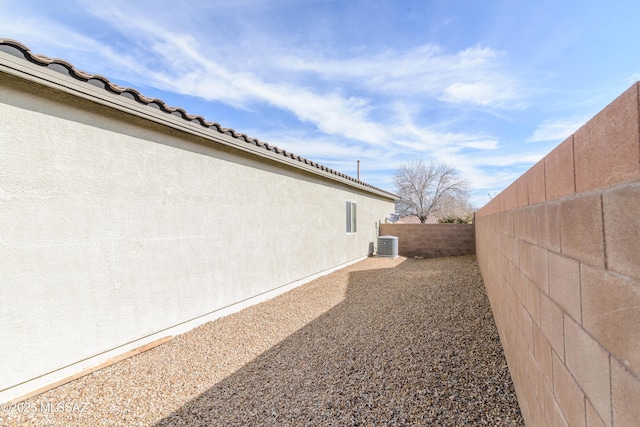 view of yard with a fenced backyard and central AC