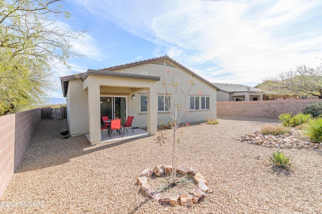 back of property featuring a tiled roof, a patio area, a fenced backyard, and stucco siding