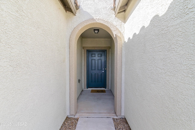 entrance to property featuring stucco siding