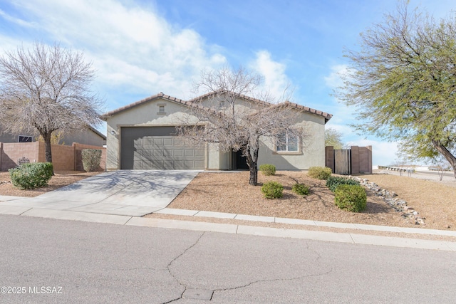 mediterranean / spanish-style home with concrete driveway, an attached garage, a gate, fence, and stucco siding