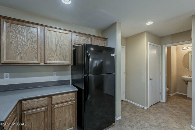 bathroom with a sink, tile patterned flooring, toilet, and baseboards