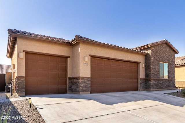 mediterranean / spanish-style home with stone siding, concrete driveway, an attached garage, and stucco siding