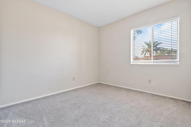 carpeted empty room with baseboards