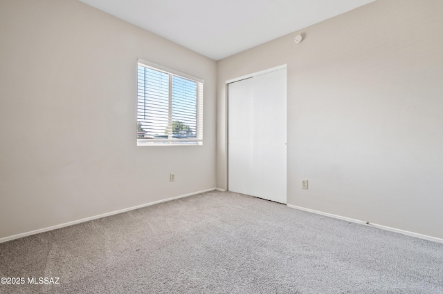 unfurnished room featuring carpet floors and baseboards