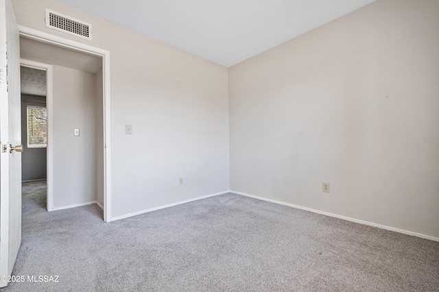 carpeted spare room with baseboards and visible vents