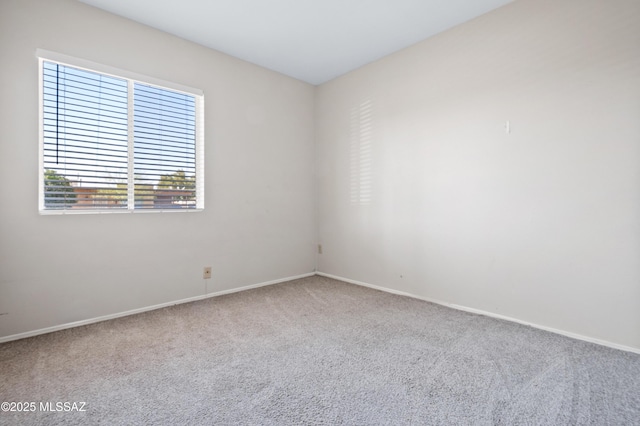 spare room featuring carpet flooring and baseboards