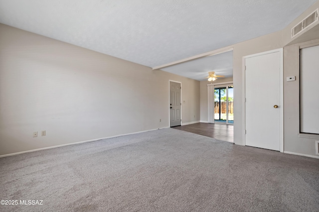 carpeted spare room featuring a ceiling fan, baseboards, visible vents, and a textured ceiling